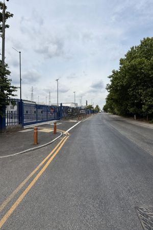 Reinstated carriageway and footway with fresh lining, timber bollards, and new kerbs after Section 278 works in Barking, East London